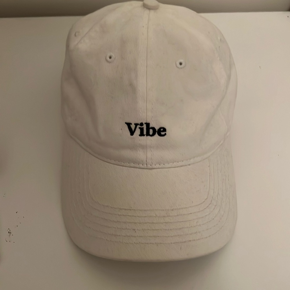 Medium size, adjustable, all white with black “Vibe” on the front